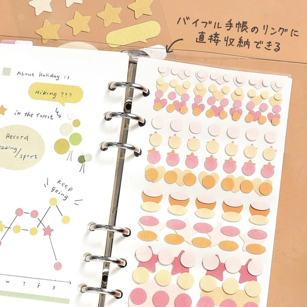 Planner with decorative stickers and text on a beige background, showing how the Daily Palette stickers by BGM Life can be attached to a ring bound planner or journal. 