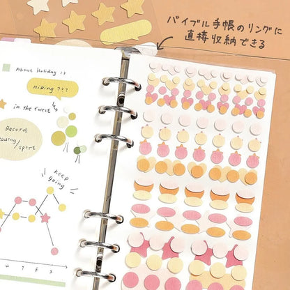 Planner with decorative stickers and text on a beige background, showing how the Daily Palette stickers by BGM Life can be attached to a ring bound planner or journal. 